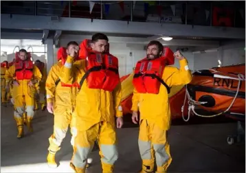  ??  ?? Lee Chin, on the left, in survival gear during the visit to the RNLI College in Poole.