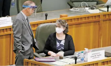  ?? LUIS SÁNCHEZ SATURNO/THE NEW MEXICAN ?? State Sen. Daniel Ivey-Soto, D-Albuquerqu­e, wears a face shield while chatting with Rep. Linda Trujillo, D-Santa Fe, on the House floor Friday during the special session.