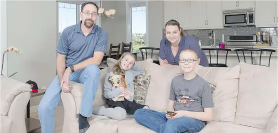  ?? DON MOLYNEAUX FOR THE HERALD ?? Seann and Shauna Eldan with daughter, Alyssa, and son, Logan, at their new home in Legacy. A key feature for the family was space for the kids to play, and from the first day, they have been enjoying new-found freedom outdoors, says Shauna.