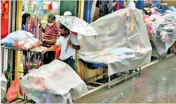  ?? ?? It was a rainy start to back to brisk business in Pettah as the lockdown was lifted on Friday .
Pix by Akila Jayawardan­a