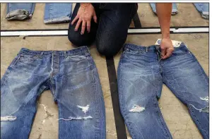 ?? AP ?? Bart Sights, head of Levi Strauss &amp; Co.’s Eureka Innovation Lab, compares the markings and damage on jeans he guesses are close to 30 years old (left) to jeans made within a few hours of this photograph.