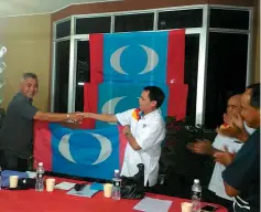  ??  ?? Abel (left) hands over PKR flag to Christophe­r to mark the opening of the new sub-branch.
