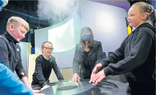  ?? ?? Clare Haughey pictured at the smoke table with pupils from Longhaugh Primary during her visit to the Dundee Science Centre yesterday.