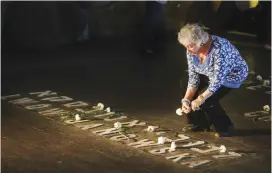  ?? (Marc Israel Sellem/The Jerusalem Post) ?? A WOMAN LEAVES flowers at Yad Vashem during the 2014 Holocaust Remembranc­e Day service there.