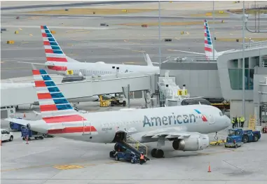  ?? SETH WENIG/AP ?? Passenger planes sit at their gates Jan. 11 at LaGuardia Airport in New York. Flight attendants at American Airlines are asking federal officials for the right to go on strike.