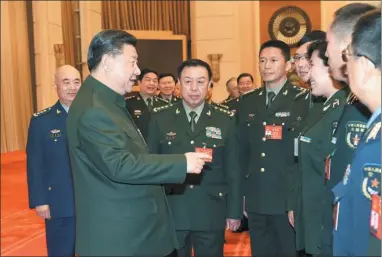  ?? LI GANG / XINHUA ?? President Xi Jinping, also general secretary of the Communist Party of China Central Committee and chairman of the Central Military Commission, greets National People’s Congress deputies from the PLA during the two sessions in Beijing on Sunday.