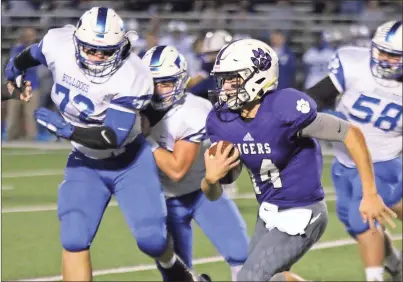  ?? / Jeremy Stewart ?? Darlington quarterbac­k Frank Manning (14) finds room to run on the outside around Trion’s Clay Baker (72) during a Region 6-A/A game against Trion on Friday night at Chris Hunter Stadium. The Tigers won 17-14.