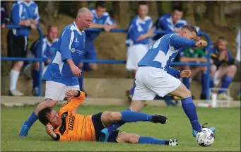  ??  ?? Taghmon United duo Joey Sinnott and Dave Goddard leave Raheen’s James Furlong on the deck.