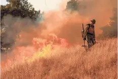  ?? PHILIP PACHECO/AFP VIA GETTY IMAGES ?? A firefighte­r sets a backfire along a hillside in Healdsburg, Calif., in October as tens of thousands of people fled out-of-control blazes in the state.