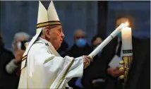  ?? REMO CASILLI/POOL VIA AP ?? Pope Francis celebrates the Easter Vigil in St. Peter’s Basilica on Saturday at the Vatican, lighting a single candle in the darkened basilica, then sharing its flame with others.