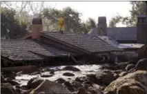  ?? THE ASSOCIATED PRESS ?? A Cal Fire search and rescue crew looks over a home damaged by storms in Montecito, Calif., on Friday.