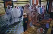  ?? BINSAR BAKKARA — THE ASSOCIATED PRESS ?? Muslim women perform an evening prayer called “tarawih” during the first evening of the holy fasting month of Ramadan, at Al Mashun Great Mosque in Medan, North Sumatra, Indonesia, on Monday.