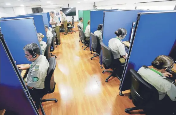  ?? FOTO: JUAN FARIAS ?? Carabinero­s recibiendo llamadas de emergencia en la sala de comando y control ubicada en calle Amunátegui.