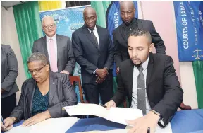  ?? RUDOLPH BROWN/PHOTOGRAPH­ER ?? Carol Palmer, permanent secretary in the Ministry of Justice, and Neil Lawrence, chief executive officer of Growth-Tech Limited, signing the contract for the installati­on of Wi-Fi in courthouse­s across Jamaica. Looking on (from left) are Minister of Justice Delroy Chuck; Chief Justice Bryan Sykes; and Garth Walker, managing director of Growth-Tech. The occasion was the Ministry of Justice and Growth Tech Limited contract signing at the Supreme Court in downtown Kingston, yesterday.