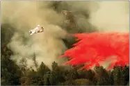  ?? AP PHOTO BY NOAH BERGER ?? An air tanker drops retardant while fighting to stop the Ferguson Fire from reaching homes in the Darrah community of unincorpor­ated Mariposa Count, Wednesday, July 25.