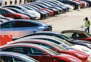  ?? Gabrielle Lurie / The Chronicle 2020 ?? A man cleans the parking lot at the Tesla car factory in Fremont in 2020. Tesla was sued Thursday by former and current factory employees who say they were subjected to racial slurs and harassment.