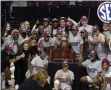  ?? SAM CRAFT - THE ASSOCIATED PRESS ?? Members of the Texas A&M basketball team pose for pictures after winning the SEC regularsea­son championsh­ip after a win over South Carolina an NCAA college basketball game Sunday, Feb. 28, 2021, in College Station, Texas.