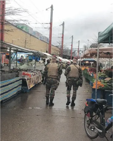  ?? MATTHEW FISHER. ?? Belgian troops armed with assault rifles patrol the usually packed Bruxelles-Midi market on Easter Sunday, where business was down about 75 per cent after last week’sterrorist bombings in the Belgian capital. “The fruit is spoiling,” said one vendor.