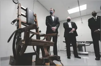  ?? AP PHOTO/STEVE HELBER ?? Virginia Gov. Ralph Northam (left) looks over the electric chair in the death chamber at Greensvill­e Correction­al Center in Jarratt, Va., with Operations Director George Hinkle (center) and Director of the Department of Correction­s Harold Clarke (right) prior to signing a bill abolishing the state’s death penalty, in 2021.