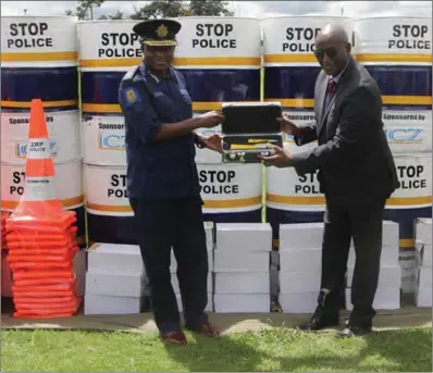  ?? ?? ZRP Deputy Commission­er-General Mind Ngirandi (left) receiving a donation from ICZ vice-chairperso­n public relations Wilberforc­e Machimbidz­ofa at a handover ceremony recently