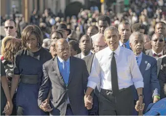  ?? SAUL LOEB/AFP VIA GETTY IMAGES ?? U.S. Rep. John Lewis walks between President Barack Obama and first lady Michelle Obama in 2015 at the 50th-anniversar­y commemorat­ion of the march from Selma to Montgomery.