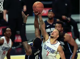  ?? JAYNE KAMIN-ONCEA/USA TODAY SPORTS ?? Los Angeles Clippers guard Amir Coffey (7) blocks a shot by Orlando Magic guard Dwayne Bacon (8) during the first half Tuesday at Staples Center in Los Angeles.