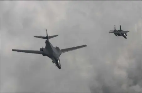  ?? SOUTH KOREA DEFENSE MINISTRY VIA AP ?? In this photo provided by South Korea Defense Ministry, a U.S. Air Force B-1B bomber, left, flies with a South Korean fighter jet F-15K over the Korean Peninsula, South Korea, Sunday. The United States flew two supersonic bombers over the Korean...