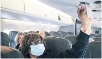  ?? ALYSSA SCHUKAR THE NEW YORK TIMES FILE PHOTO ?? Experts say given the tight spaces, it’s wise to wear protective gear on an airplane to prevent the spread of the coronaviru­s.