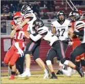  ??  ?? Blackhawks Justin Koon (No. 16) and Garrett Brooks (No. 30) combined forces to bring down the Tiger ball carrier in the Friday night game against Green Forest.