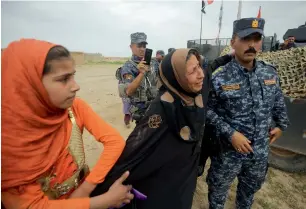  ?? AFP ?? Displaced Iraqis react as they evacuate from their homes in Al Haramat neighbourh­ood, north of Mosul, as Iraqi forces advance towards the area during the ongoing offensive to retake Mosul from the Daesh group fighters on Friday. —