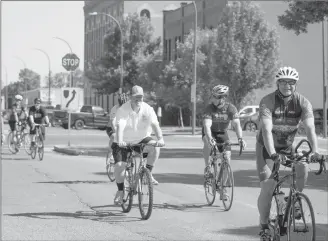  ?? Herald photo by Greg Bobinec ?? Law enforcemen­t members start pedalling to Edmonton Friday on their 15th annual torch run.