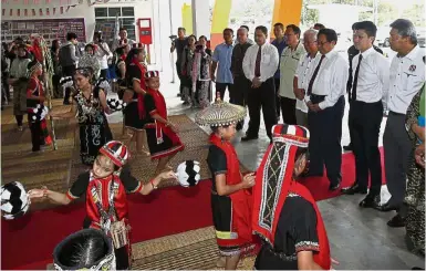  ??  ?? Welcome:
SK Landeh pupils performing a traditiona­l dance to welcome Abang Johari (third from right) and Chong (second from right) to the school’s opening ceremony.