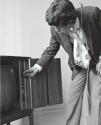  ??  ?? I can’t get no reception: Mick Jagger fiddles with the knobs of his ‘huge’ TV set at his home in Harley House, a prestigiou­s mansion block in London’s Marylebone