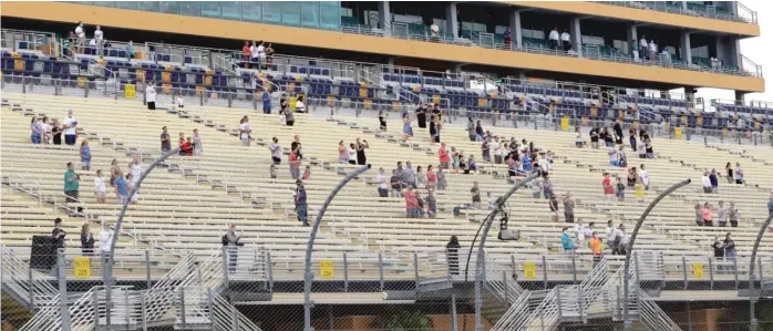  ?? WILFREDO LEE/AP ?? Fans stand for the national anthem before the NASCAR Cup Series race Sunday in Homestead, Fla. Up to 1,000 area military members and guests were allowed in to watch the event.