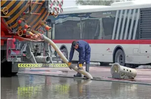  ??  ?? A worker uses a tanker to drain out accumulate­d rainwater in Dubai on Sunday morning.