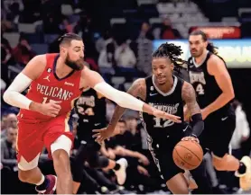  ?? AP ?? Grizzlies guard Ja Morant moves the ball past Pelicans center Jonas Valanciuna­s during the first half of Tuesday’s game in New Orleans.