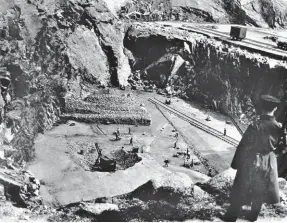  ??  ?? Much-evolved, in terms of size, this official photograph shows Stirling Hill quarry on a working day – the guard keeping watch from high ground is armed with a Lee-Enfield rifle over his right shoulder, and with a bayonet too. Work was carried out on two distinct areas, as seen, with activity at this time concentrat­ed on the lower floor. Using sledgehamm­ers, prisoners reduced the granite to an approximat­ely consistent size for transporti­ng to the work sites, a growing pile being seen centre left. Note the excavator on the lower level, along with a rail-mounted crane, but most of the railway in view is at the higher level, the means of lifting the rock to the higher level being just out of view to the right of the prison officer. ‘Hard Labour’ as a sentence was discontinu­ed in 1948, and perhaps the photograph­er is on hand around that time when a some mechanisat­ion was introduced for some of the jobs undertaken by convicts. Maud Railway Museum Collection