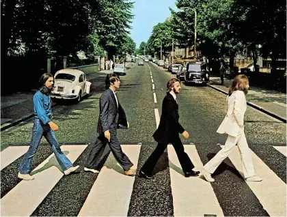  ?? ?? Iconic: The Beatles walked down the street to a zebra crossing to shoot the cover of Abbey Road