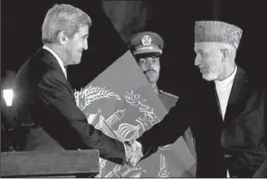  ?? AP/JACQUELYN MARTIN ?? U.S. Secretary of State John Kerry wraps up Saturday’s news conference in Kabul with a handshake with Afghan President Hamid Karzai.