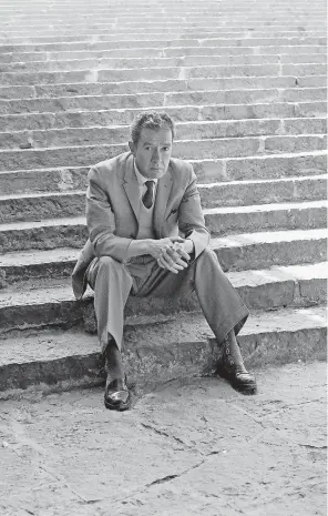  ??  ?? Juan Rulfo sentado al pie de la escalinata que conduce a la torre de Rectoría, en Ciudad Universita­ria.