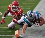  ?? (AP/Jeff Roberson) ?? Carolina Panthers running back Christian McCaffrey (right) is knocked out of bounds by Kansas City Chiefs safety Armani Watts during the second half Sunday in Kansas City, Mo. The Chiefs won 33-31 to extend their winning streak to four games.