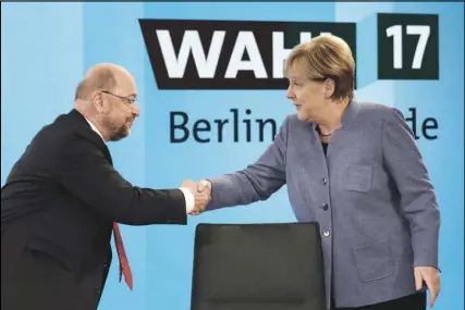  ?? AP PHOTO ?? German Chancellor Angela Merkel, head of the Christian Democratic Party CDU, is greeted by her her challenger Martin Schulz, head of the Social Democratic Party SPD, prior to a TV talk of the party leaders in Berlin yesterday after the German...