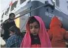  ?? ORESTIS PANAGIOTOU/EPA-EFE ?? Refugees wait for transport after they arrived on the ferry Nissos Samos from Lesbos island at the port of Piraeus, Greece, on Dec. 11.