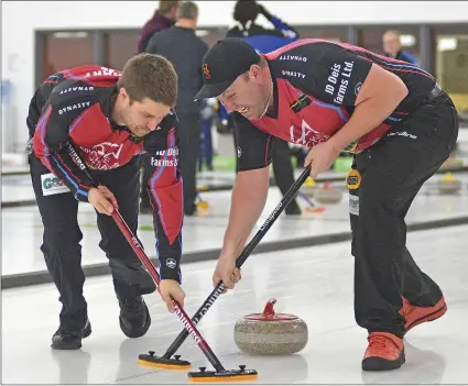  ?? STEVEN MAH/SOUTHWEST BOOSTER ?? Jason Barnhart (left) and Kalin Deis swept a rock for Team Deis during their opening game at the Saskatchew­an Player’s Championsh­ip in Swift Current on Friday.