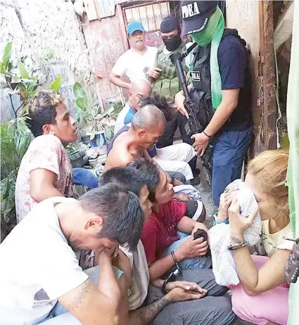  ?? / GIKAN SA PDEA 7 ?? ■NANAGTUK-ONG: Ang nangasikop gikan sa usa ka drug den sa Barangay Duljo Fatima, dakbayan sa Sugbo kagahapon sa hapon ang gipatuk-ong sa awtoridad samtang tulo ka mga ahente sa Philippine Drug Enforcemen­t Agency (PDEA) nagbarog nga nagbantay kanila sa wala pa pangdad-a sa buhatan sa PDEA.