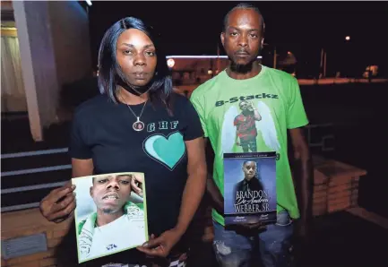  ?? JOE RONDONE/THE COMMERCIAL APPEAL ?? Jaleta Clark and Sonny Webber, parents of Brandon Webber, hold photos of their son, who was shot and killed by U.S. Marshals in June of 2019.