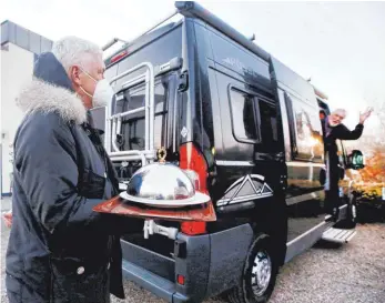  ?? FOTO: ROLAND WEIHRAUCH/DPA ?? In Nordrhein-Westfalen hat der Gastwirt des Restaurant­s „Bootshaus Ruhreck" seinem Gast das Essen ans Wohnmobil gebracht. Diese Idee wird nun auch von der Rose in Ehingen umgesetzt.