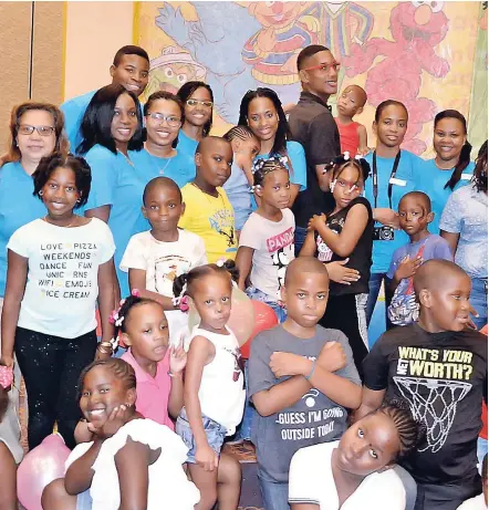  ??  ?? Human Resource Manager Joy Chung (left) and other team members (in blue) pose with some of the children attending the treat.