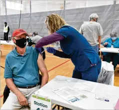  ?? HYOSUB SHIN/ HYOSUB. SHIN@ AJC. COM ?? Registered Nurse Heather Nobles administer­s a COVID- 19 vaccine to Randy Alford in Albany, Georgia, last month. More and more states are expanding the eligibilit­y of people to get the shots.