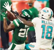  ?? Michael Reaves / Getty Images ?? The Jets’ Marcus Maye (20) intercepts a pass meant for the Dolphins’ Preston Williams during the second half of their game on Sunday at Hard Rock Stadium in Miami Gardens, Fla.